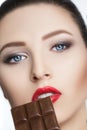 Attractive woman with red lipstick eats chocolate Royalty Free Stock Photo