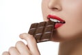 Attractive woman with red lipstick eats chocolate Royalty Free Stock Photo