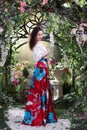 Attractive woman in red skirt in floral garden. Fairy tale Royalty Free Stock Photo