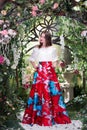 Attractive woman in red skirt in floral garden. Fairy tale Royalty Free Stock Photo