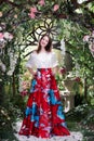 Attractive woman in red skirt in floral garden. Fairy tale Royalty Free Stock Photo