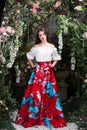 Attractive woman in red skirt in floral garden. Fairy tale Royalty Free Stock Photo