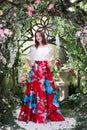 Attractive woman in red skirt in floral garden. Fairy tale Royalty Free Stock Photo