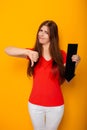 Attractive woman in a red t-shirt is holding a down arrow. Royalty Free Stock Photo