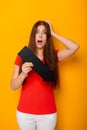 Attractive woman in a red t-shirt is holding a down arrow. Royalty Free Stock Photo