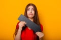 Attractive woman in a red t-shirt is holding a down arrow. Royalty Free Stock Photo