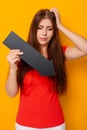 Attractive woman in a red t-shirt is holding a down arrow. Royalty Free Stock Photo