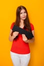 Attractive woman in a red t-shirt is holding a down arrow. Royalty Free Stock Photo