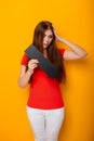 Attractive woman in a red t-shirt is holding a down arrow. Royalty Free Stock Photo