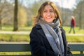 Attractive woman relaxing on a park bench with a happy smile Royalty Free Stock Photo