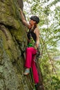 Attractive woman rock climbing with ropes in Rudawy Janowickie in Poland