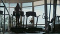 Attractive woman running on treadmill in sport gym