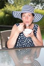 Attractive woman siiting by the pool and eating a bowl of fruit