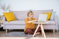Attractive woman sitting on floor and sofa using laptop chatting while working Royalty Free Stock Photo