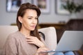 Attractive woman sitting at home and using laptop Royalty Free Stock Photo