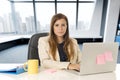 Attractive woman sitting at office chair working at laptop computer desk Royalty Free Stock Photo