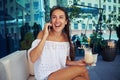 Attractive woman sitting on open terrace with cocktail in her ha