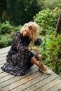 attractive woman sitting and posing on wooden footbridge