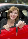 Attractive woman smiling proud sitting at driver seat holding and showing car key in new automobile buying and renting Royalty Free Stock Photo