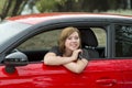 Attractive woman smiling proud sitting at driver seat holding and showing car key in new automobile buying and renting