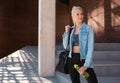 Attractive woman in sportswear walking to a gym outdoor. Sport, jogging, healthy and active lifestyle. Royalty Free Stock Photo