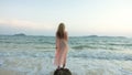 Woman stand on a reef rock stone in sea on sunset. Girl on beach Royalty Free Stock Photo