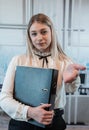 Attractive woman standing alone at the office and hold folder for paper documents Royalty Free Stock Photo