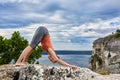 Attractive woman standing on the rock and doing yoga exercises above river. Royalty Free Stock Photo