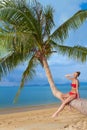 Attractive woman sunbathing on a palm tree Royalty Free Stock Photo