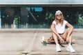 Attractive woman relaxing sitting on the longboard Royalty Free Stock Photo