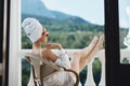 Attractive woman in sunglasses sits on the balcony and uses the phone Lazy morning Royalty Free Stock Photo