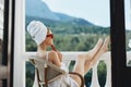 Attractive woman in sunglasses sits on the balcony and uses the phone Lazy morning Royalty Free Stock Photo