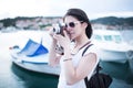 Attractive woman taking pictures with vintage retro camera laughing and smiling happy during summer holiday vacation travel Royalty Free Stock Photo