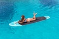 Attractive woman is tanning on a surfboard Royalty Free Stock Photo