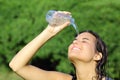 Attractive woman throwing herself water from a bottle