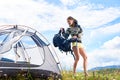 Woman tourist hiking in mountain trail, enjoying summer sunny morning in mountains near tent Royalty Free Stock Photo