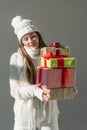 attractive woman in trendy winter sweater and scarf holding presents isolated
