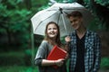 Attractive woman with umbrella and branch of lilac, on the street at rain