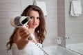 Attractive woman using fen in bathroom Royalty Free Stock Photo