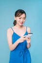 Attractive woman using text messaging feature on her portable device in studio Royalty Free Stock Photo