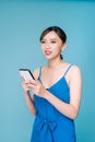Attractive woman using text messaging feature on her portable device in studio Royalty Free Stock Photo