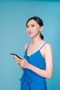 Attractive woman using text messaging feature on her portable device in studio Royalty Free Stock Photo