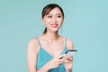 Attractive woman using text messaging feature on her portable device in studio