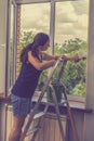 Attractive Woman Washing the Window. Cleaning Company worker working. Young woman washing window, close up. Cute girl with Royalty Free Stock Photo