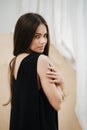 Attractive woman wearing a black V-neck dress looking over her shoulder Royalty Free Stock Photo