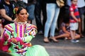 woman dancing in traditional mexican dress in front of people sitting on steps