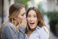 Attractive woman whispering secret in friend`s ear Royalty Free Stock Photo