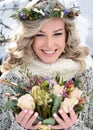 Attractive woman with white teeth and a perfect smile holds a bouquet of roses and fir branches. Happy sincere winter outdoor Royalty Free Stock Photo