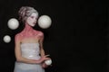 Attractive woman witch fairy standing with white planet spheres on black background. Royalty Free Stock Photo