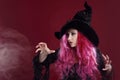 Attractive woman in witches hat and costume with red hair. Halloween Royalty Free Stock Photo
